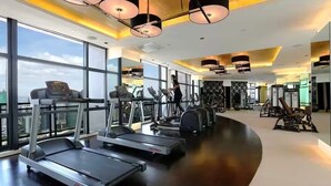 Un gimnasio moderno con cintas de correr, elípticas y equipo de levantamiento de pesas.