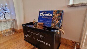 A storage bin labeled "petit rangement pour Jolies choses" with a Super Cluedo Interactive game box inside. - The House of Mountains (Le Thillot)
