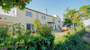 Une maison à deux étages avec un jardin à l’avant.