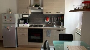 A modern kitchen with a refrigerator, stove, oven, and cabinets. - B&B Il Dolce Dormire offers comfort and style in one. (Ponte Valleceppi)