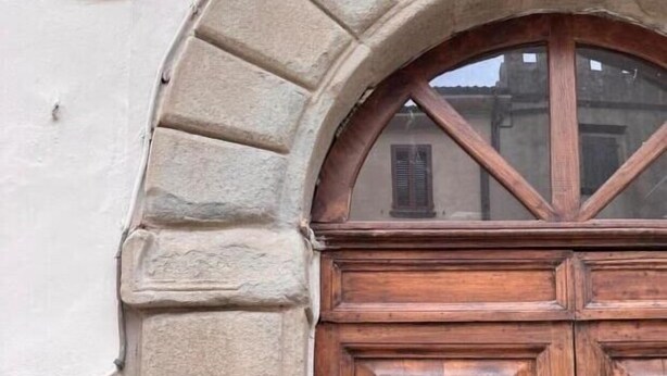 A wooden double door with a circular handle, set within a stone archway. - Maison Ventiquattro Suite & Spa (Talamello)