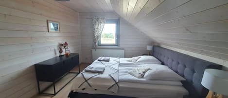 Ein Schlafzimmer mit einem Bett, einem Schminktisch, einem Fenster und einer Lampe.