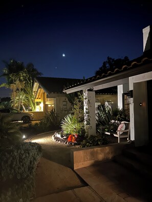 A house with a covered patio, a car parked in front, and a garden with various plants. - Casa Sharman in Solana Beach welcomes you to live with ease and joy. (Solana Beach)