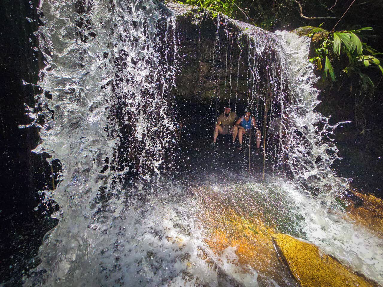 Una cascada con una persona sentada en el centro.
