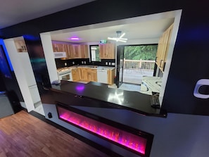 Una cocina moderna con armarios de madera, estufa empotrada y un ventanal con vistas a una terraza.