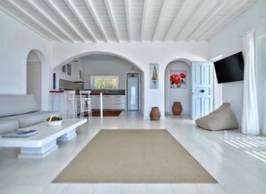 Ein modernes Wohnzimmer mit einer Couch, einem Couchtisch und einem Fernseher.
