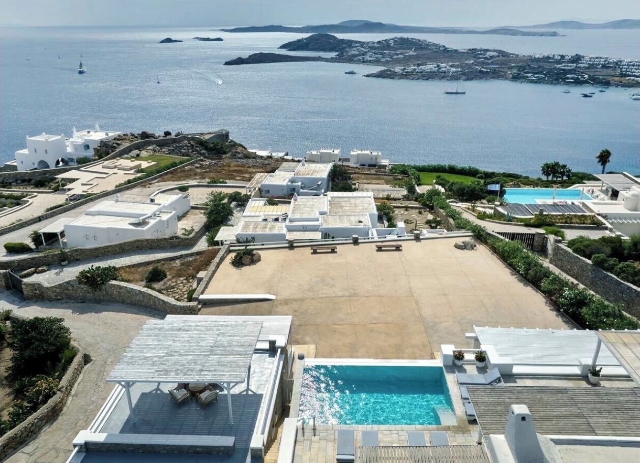 Un complexe hôtelier doté d’une piscine, de chaises longues et offrant une vue sur la mer.