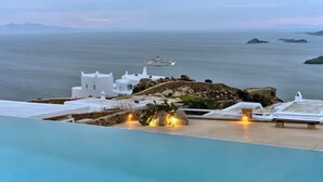 Vista a la piscina con vista al mar y un crucero en la distancia.