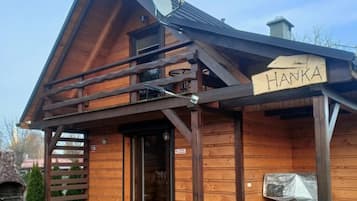 Una cabaña de madera con un cartel que dice 'HANKA' y una antena parabólica.