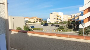 A residential area with multi-story buildings, a parking lot, and a clear sky.