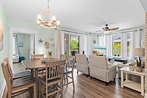 A dining area with a wooden table and chairs, a chandelier, and a ceiling fan. - 🏖️Lagoon Pool | Hot Tub | Walk to Baytowne Wharf | Market Street Inn 248☀️ (Miramar Beach)