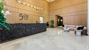 A modern reception area with a marble counter, a sofa, and a potted plant. - 2BR + Den Downtown Miami for 5 (Miami Beach)