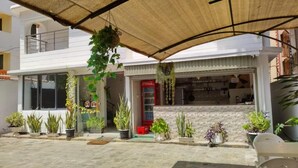 Een gebouw met een overdekte patio, potplanten en een Coca-Cola koelkast.