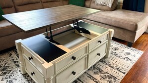 A living room with a sofa, a coffee table, and a storage unit with drawers. - Hot Tub Outdoor Living Game Room Coffee Bar (South Bend)