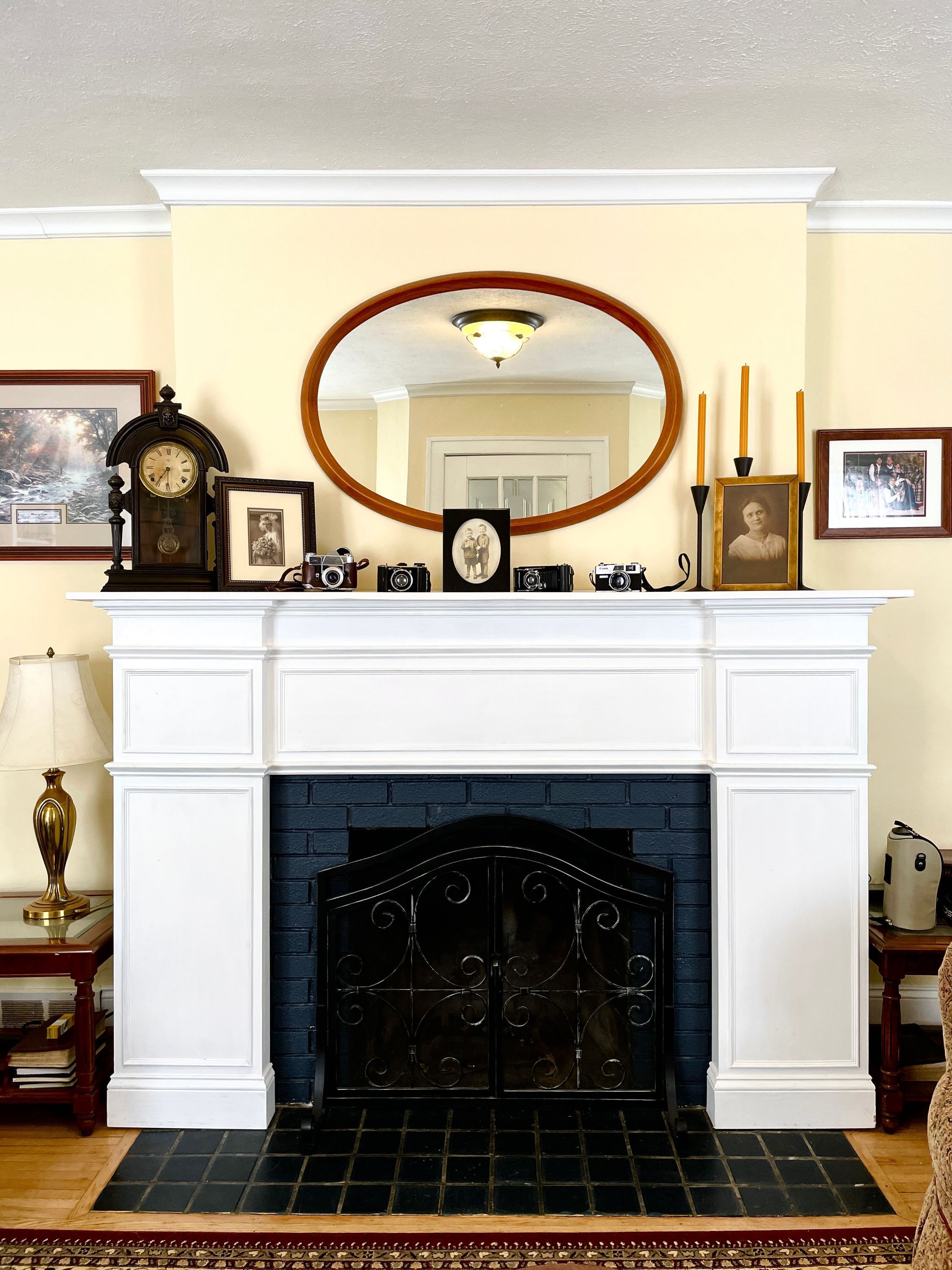 A fireplace with a white mantel, a black brick surround, and a mirror above it.