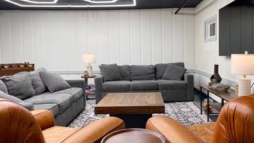 A modern living room with a grey sectional sofa, a brown leather sofa, and a wooden coffee table.