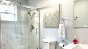 A bathroom with a glass-enclosed shower, a toilet, a sink, and a towel hanging on the wall. - Sarasota Family Home Private Heated Pool Relax (Sarasota)