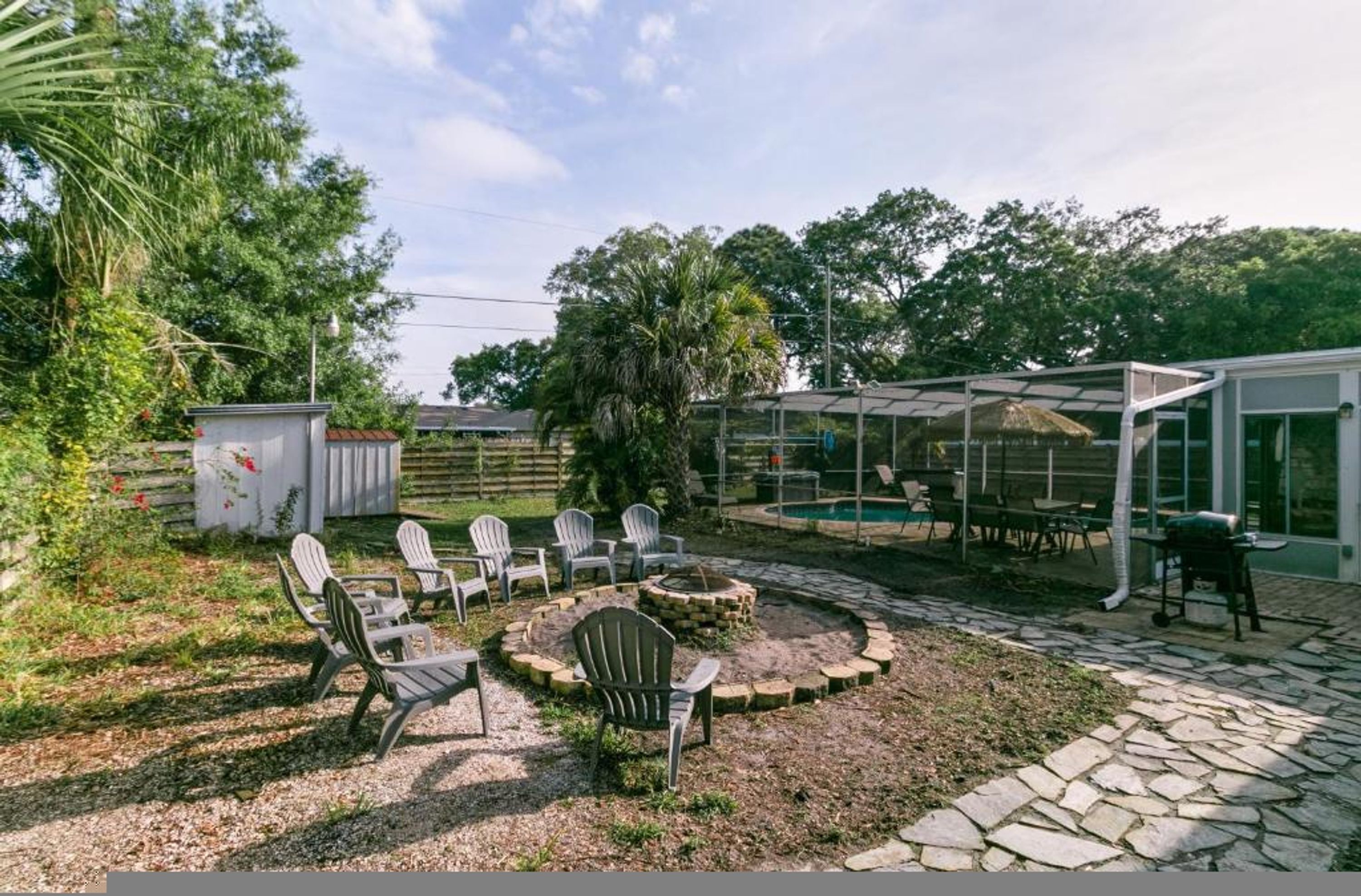 A patio area with Adirondack chairs, a fire pit, and a covered seating area.