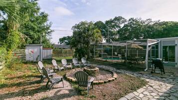 A patio area with Adirondack chairs, a fire pit, and a covered seating area.