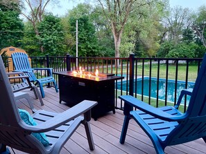 A deck with outdoor seating and a fire feature, overlooking a swimming pool. - Pool Kayaks Hot Tub Game Rooms Sleeps 16 (South Bend)