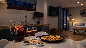 Eine moderne Küche mit Essplatz, gedecktem Tisch, einem großen Topf Essen und einer Karaffe zum Trinken.