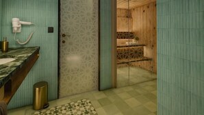 A bathroom with a marble sink, a hairdryer, and a patterned floor. - Le Marrakech Boutique Hotel (Kleinblittersdorf)