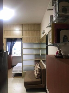 A compact living space with a kitchenette, a sofa, and a window with curtains. - Comfort Meets Convenience
Perfect for Business or Leisure
Secure &Stylish Living (Taguig)