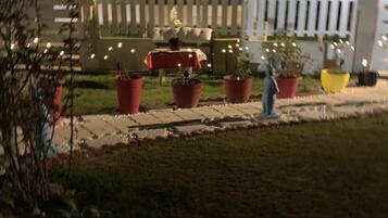 Een woonwijk in de avond met huizen, een witte picket fence en potplanten.
