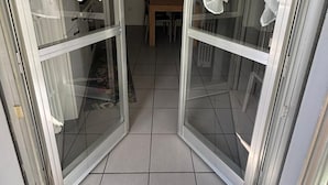 A room with a tiled floor, a wooden table, and a wall clock. - Beachfront with ⛱️ umbrella included (Pescara)