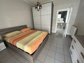 A bedroom with a bed, a wardrobe, a desk, and a chair. - Beachfront with ⛱️ umbrella included (Pescara)