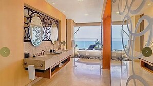 A modern bathroom with a large mirror, two sinks, and a view of the ocean. - Magnificent Ocean view suite with private balcony jacuzzi (Puerto Vallarta)