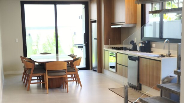 Une cuisine moderne dotée d’un îlot central, d’appareils électroménagers intégrés et d’un escalier menant à un niveau supérieur.