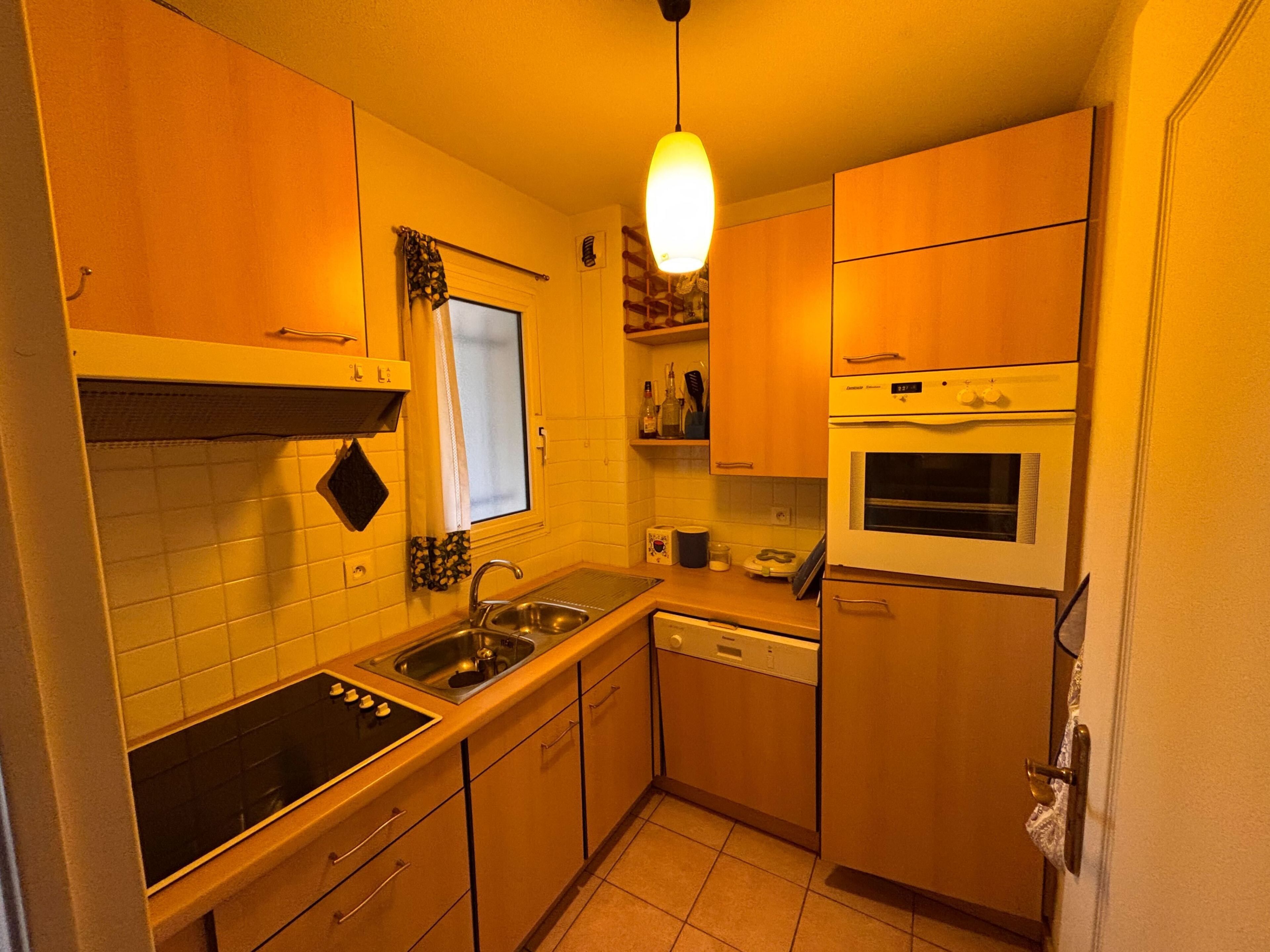 Une cuisine de taille réduite équipée d’une cuisinière, d’un évier, d’un four et d’un lave-vaisselle.