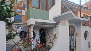 Un bâtiment à l’extérieur blanc, avec une base verte et un portail en métal.