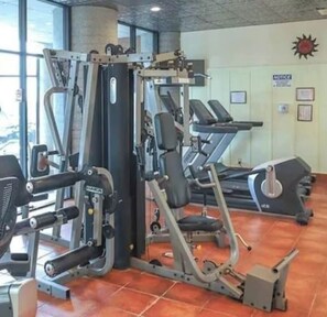 A gym with various exercise machines, including a squat rack and treadmills. - Charming Ever Green 2-Bedroom Condo in Sugar Mountain with Resort Amenities (Sugar Mountain)