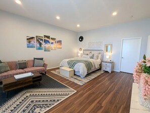Une chambre à coucher comprenant un lit, des tables de chevet, un canapé et une table basse.