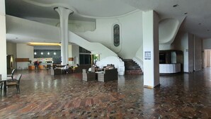 A spacious lobby with a wooden floor, a staircase, and a reception desk. - Spectacular View: Beachfront Apartment, La Palapa (Acapulco de Juárez)