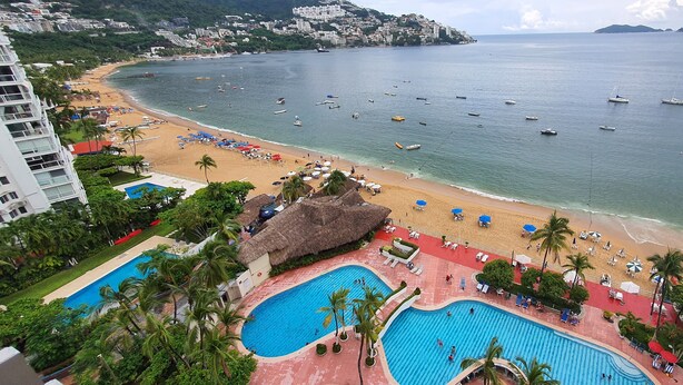 A resort with a beach, swimming pools, and boats on the water. - Spectacular View: Beachfront Apartment, La Palapa (Acapulco de Juárez)