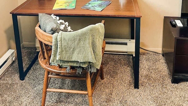 A room with a wooden desk, a chair, a painting, a plant, and a TV. - NDSU Efficiency (APT 3) (Fargo)