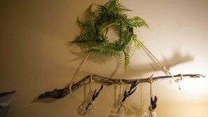 Una decoració penjada a la paret, amb una branca i elements penjants.