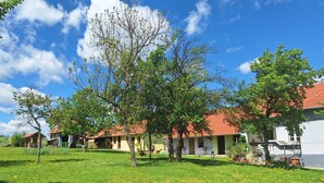 A row of houses with red roofs, surrounded by green lawns and trees. - Romantic vacation apartment with large garden - 2 min. from private natural swimming lake (Kerkateskánd)