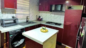 Uma cozinha compacta com uma ilha central, forno embutido e micro-ondas.