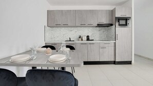A modern kitchen with grey cabinets, a marble countertop, and a built-in microwave. - Elegant Appt - 1BDR/4P - Near Paris & La Défense (Suresnes)