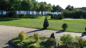 A well-maintained lawn with a concrete pathway, trees, and a swing set. - Mobile Home im Ferienpark mit Seezugang (Dabel)