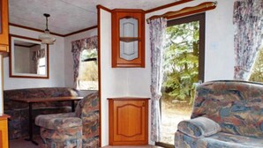 Ein kompakter Wohnbereich mit einer Couch, einem kleinen Tisch und einem Schrank.
