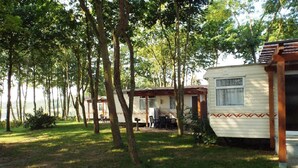 Ein Campingplatz mit Wohnmobilen und einem Picknicktisch in bewaldeter Landschaft.