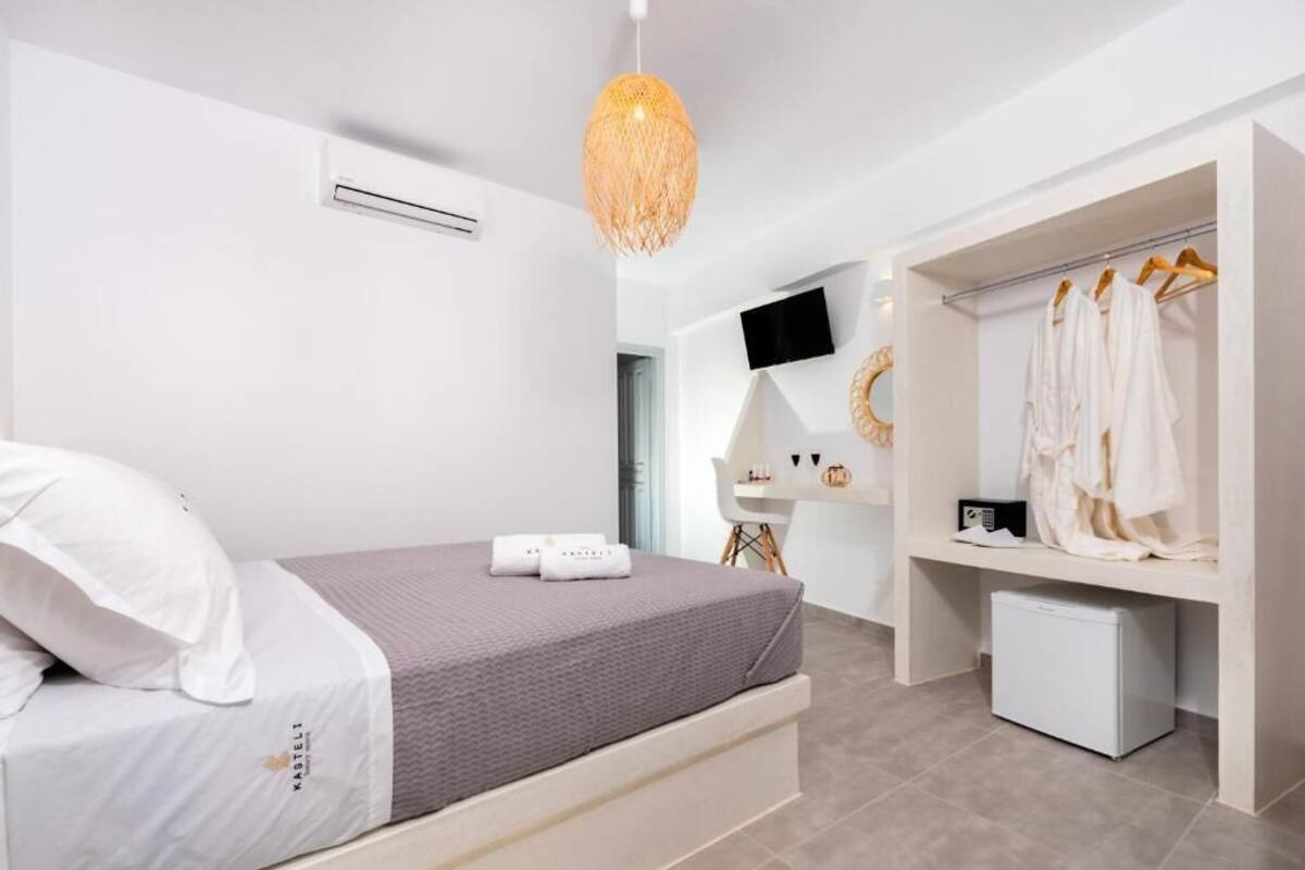 Een moderne slaapkamer met een bed, een kledingkast, een bureau en een hanglamp.