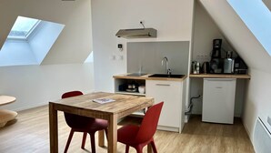 A compact kitchen with a built-in sink, a small refrigerator, and a coffee maker.