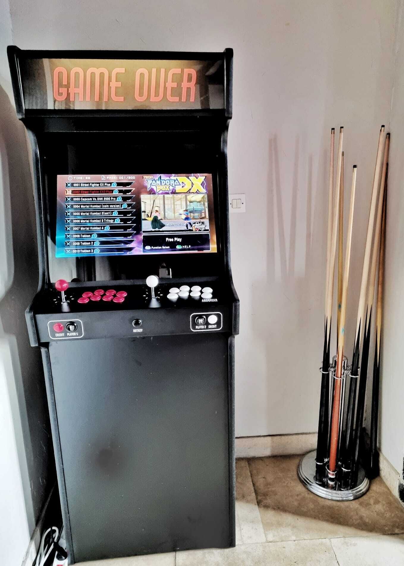 Una mesa de billar con una pantalla digital que muestra una interfaz de juego, un letrero que dice 'CAME OVER' y varios tacos.