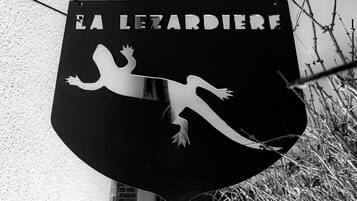 Een zwart-wit bord met de tekst 'EA LEZARDIERE' en een silhouet van een hagedis.